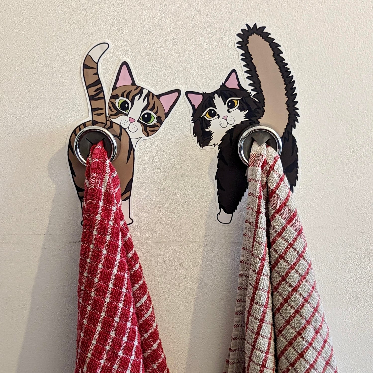 Image of two cat butts with tea towel holders and tea towels hanging from them
