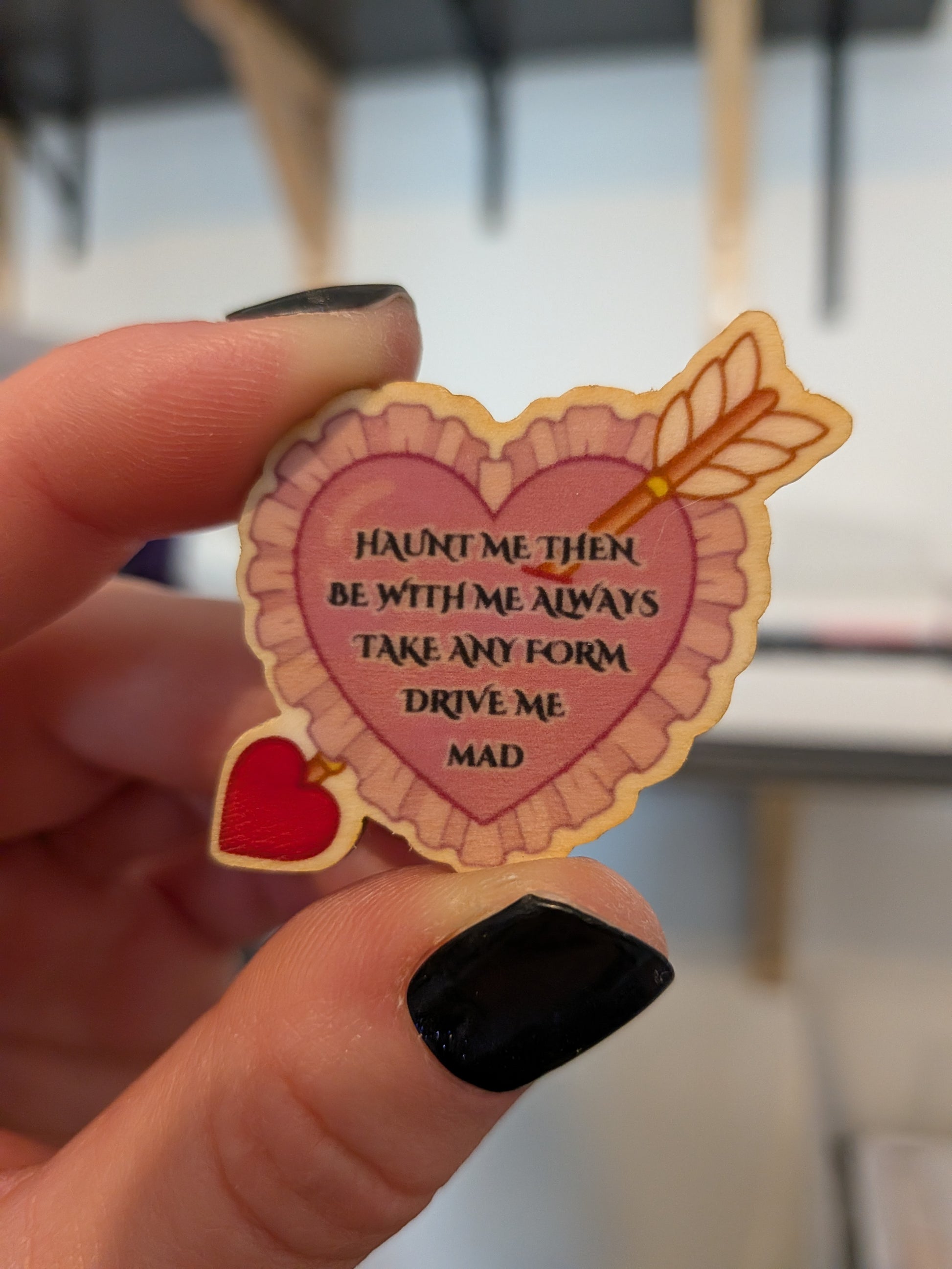 home made eco friendly wooden pin with a heart and an arrow, and the quote by Heathcliff towards Cathy "haunt me then. Be with me always. Take any form. Drive me mad."

Inspired by Wuthering Heights